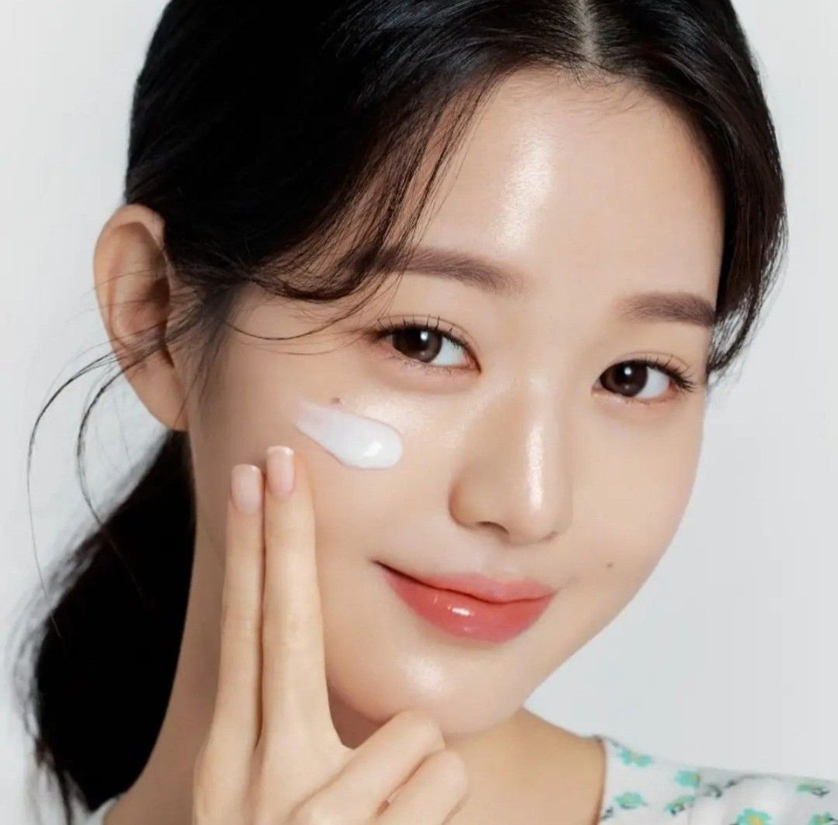 Modèle K-Beauty appliquant une crème de soin sur le visage